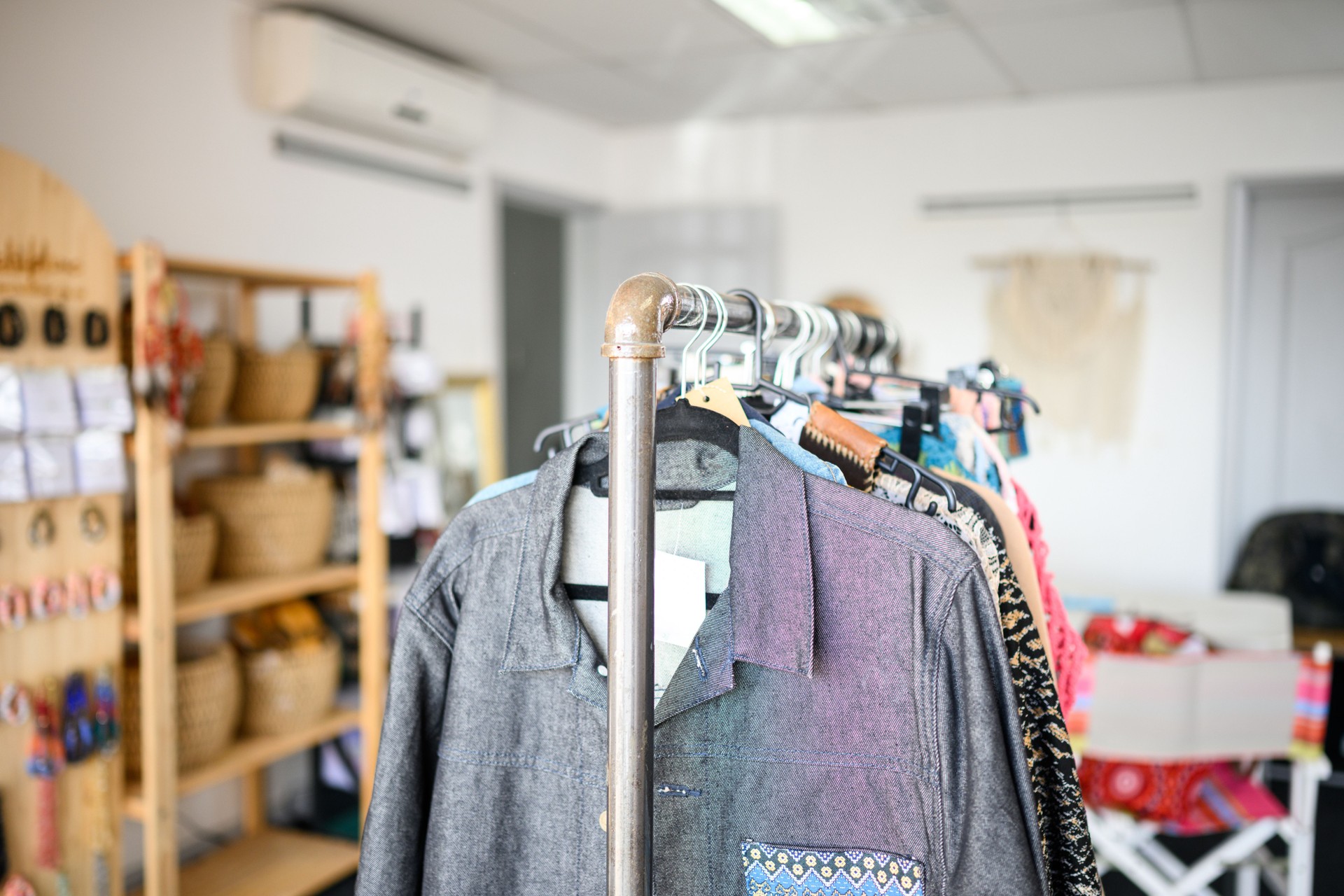 Closeup of clothing rack displaying handmade apparel in a local boutique, focus on foreground