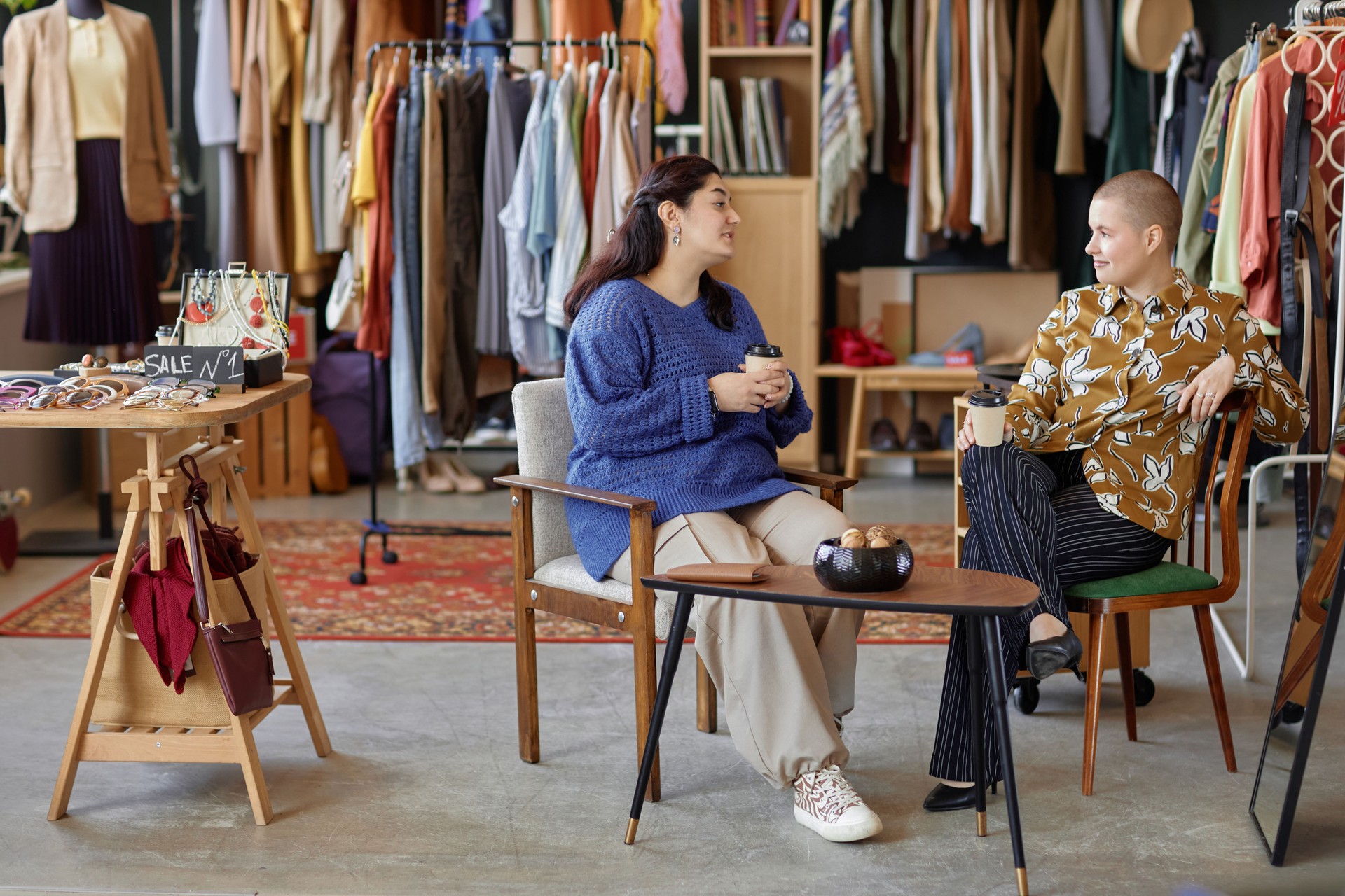 Two Women Chatting in Vintage Colorful Interior of Thrift Store